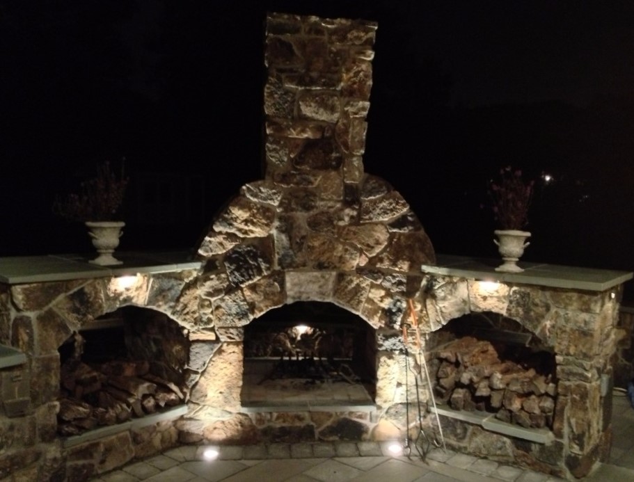 Outdoor Stone Fireplace Lit Up at Night